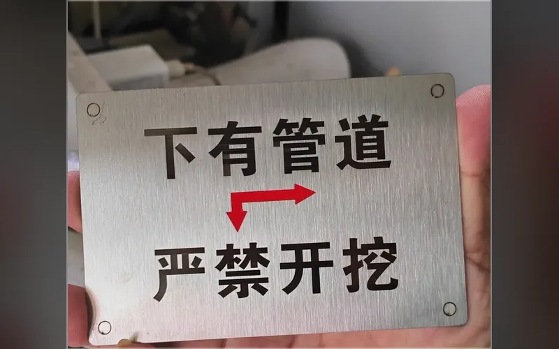 合肥激光打标代工实拍 · 304 拉丝不锈钢警示牌激光打标「下有管道 严禁开挖」，字口平整不发毛、耐磨耐晒，市政物业工地告示牌常用