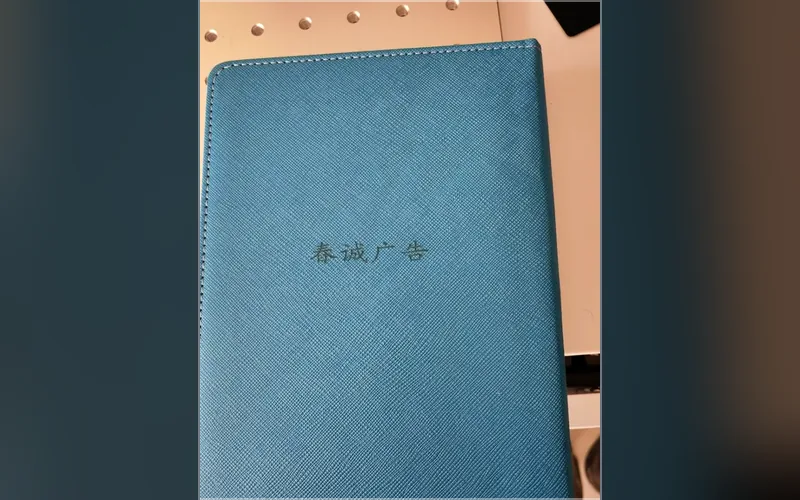 合肥激光打标代工实拍 · 深蓝色荔枝纹皮革笔记本封面激光雕刻「春诚广告」字样，凹痕均匀无焦边
