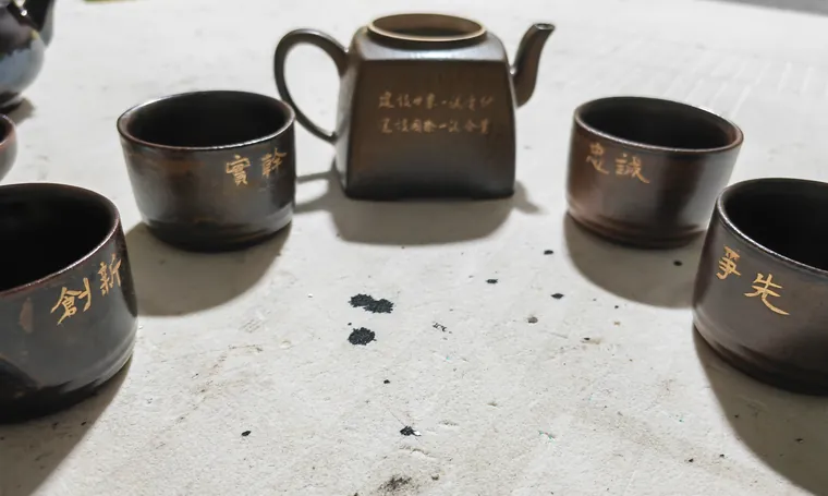 合肥激光打标代工实拍 · 紫砂茶具一套四杯激光刻字「实干 忠诚 创新 争先」，壶身刻小字落款，字口深浅均匀、釉面不崩裂