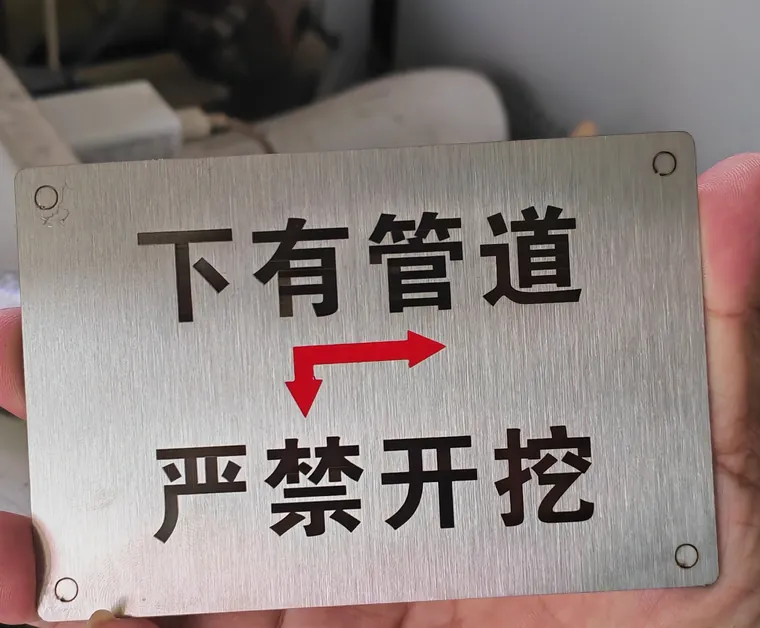 合肥激光打标代工实拍 · 304 拉丝不锈钢警示牌激光打标「下有管道 严禁开挖」，字口平整不发毛、耐磨耐晒，市政物业工地告示牌常用
