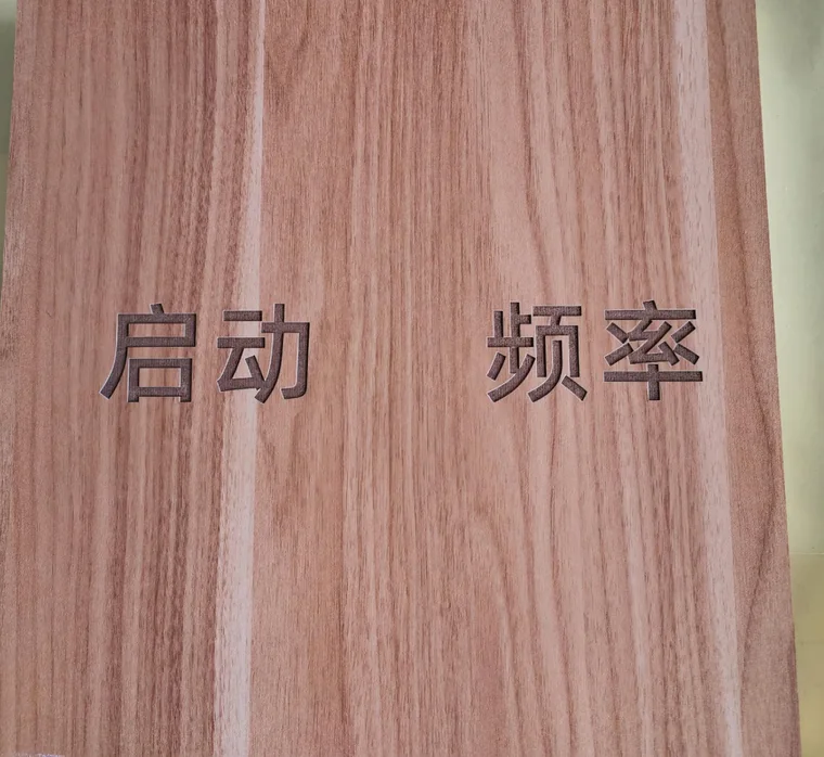 合肥激光打标代工实拍 · 木纹木板激光雕刻「启动」「频率」字样，字口凹陷、边缘烧灼自然不发糊，木材类指示牌、木盒与礼品刻字常用